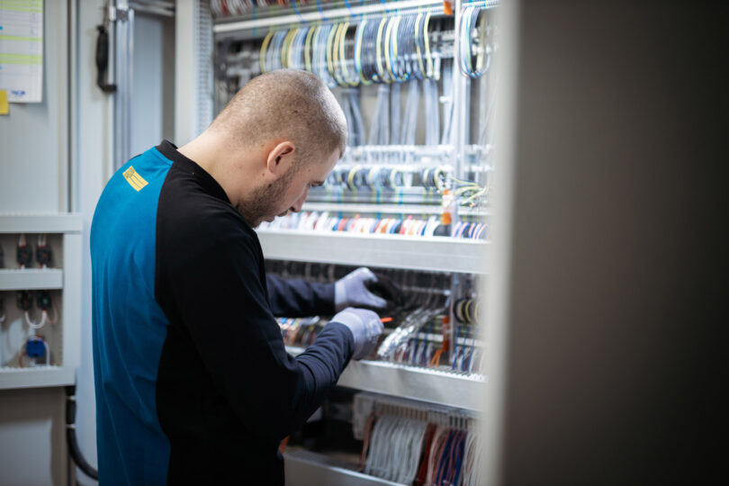 Elektroinstallateur bei der Arbeit an einer Steuerungsanlage